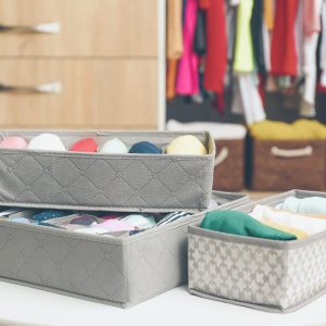 Összehajtott ruhák dobozokban gardróbrendezés közben